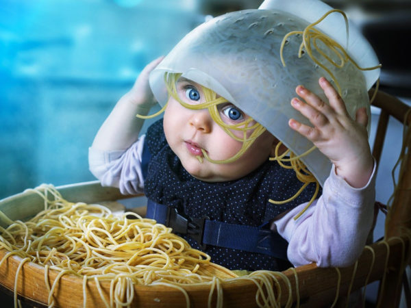Bambino con spaghetti in testa