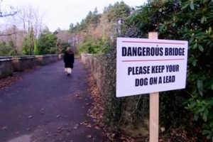 Cartello pericolo per cani a Overtoun Bridge, Scozia